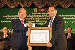 ឯកឧត្តម​ឧបនាយករដ្ឋមន្ត្រី គាត ឈន់ រដ្ឋមន្ត្រី​ក្រសួង​សេដ្ឋកិច្ច និង​ហិរញ្ញវត្ថុ និង​ជា​ប្រធាន​គណៈកម្មការ​មូលបត្រ​កម្ពុជា ប្រគល់​​អាជ្ញាប័ណ្ណ​ធ្វើ​ជា​ភ្នាក់ងារ​ទូទាត់​សាច់ប្រាក់​ពាក់ព័ន្ធ​នឹង​មូលបត្រ ជូន​លោក អ៊ិន ចាន់នី ប្រធាន​នាយក​ប្រតិបត្តិ​ធនាគារ​អេស៊ីលីដា